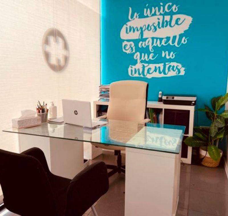 Imagen de despacho con muebles blancos y pared del fondo azul con frase escrita con letras blancas