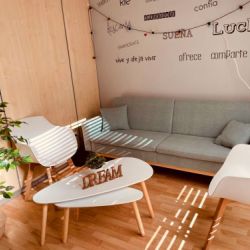 Imagen de sala de espera con muebles blancos y tonos claros y sofá en color verde agua